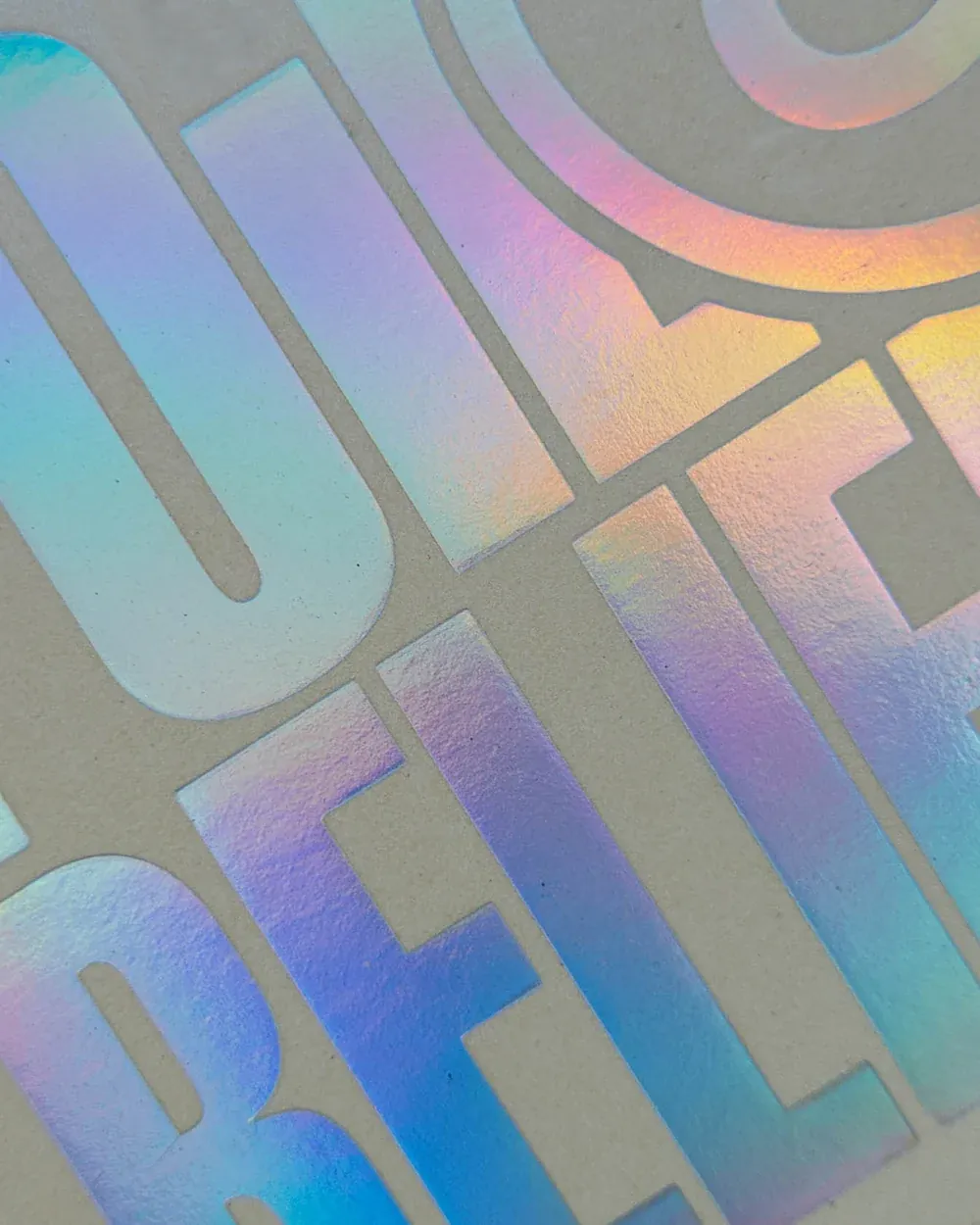 Tecnica di stampa a foil olografico su packaging di alta qualità, con riflessi luminosi e un design esclusivo.