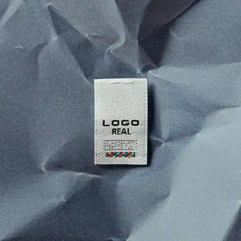 Etichetta tessuta personalizzata bianca con logo nero LOGO REAL prodotta da CO&IN