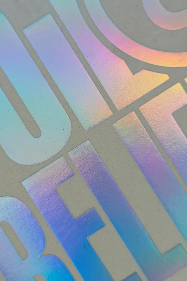 Tecnica di stampa a foil olografico su packaging di alta qualità, con riflessi luminosi e un design esclusivo.